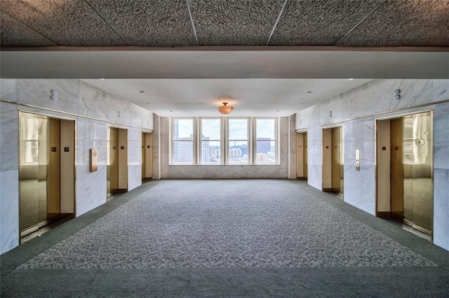 carpeted spare room with elevator