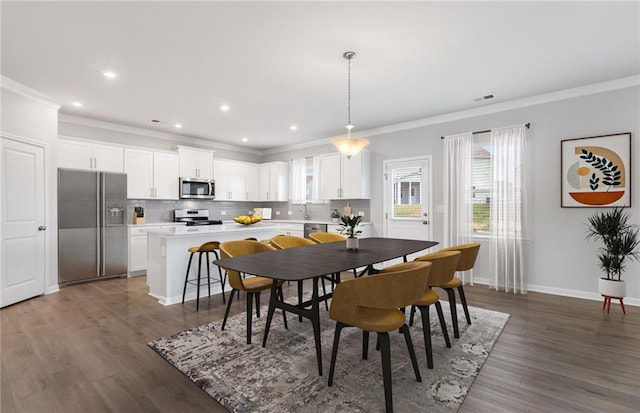 dining area with dark hardwood / wood-style flooring and ornamental molding