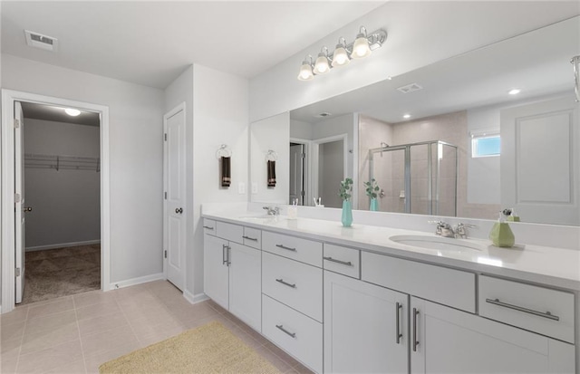 bathroom featuring a shower with shower door, tile patterned floors, and vanity