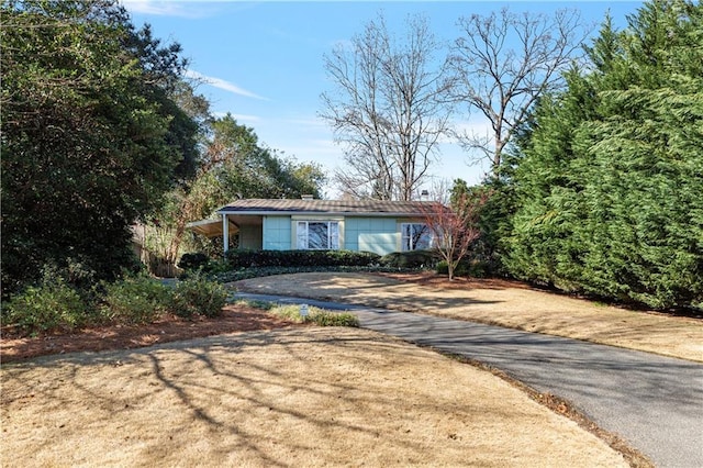 single story home with driveway and a front lawn