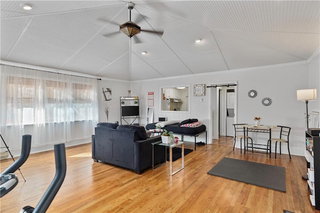 living room featuring crown molding, wood finished floors, vaulted ceiling, and a barn door