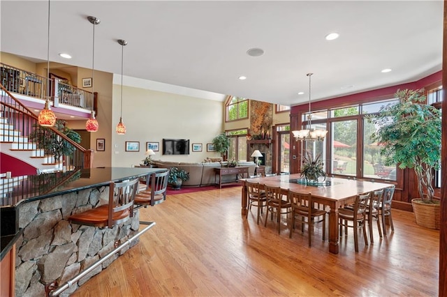 dining area featuring wood-type flooring, a fireplace, and a chandelier