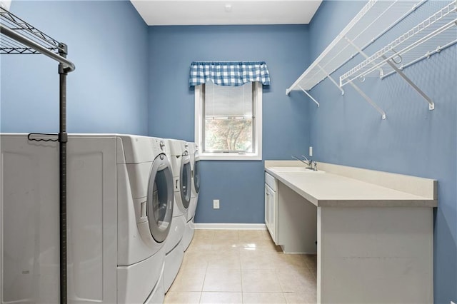 laundry room featuring cabinets, washing machine and dryer, sink, and light tile patterned floors