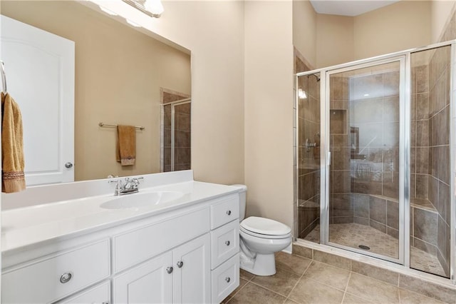 bathroom with tile patterned flooring, vanity, an enclosed shower, and toilet