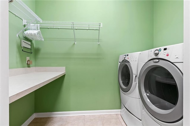 clothes washing area featuring washer and clothes dryer and light tile patterned floors