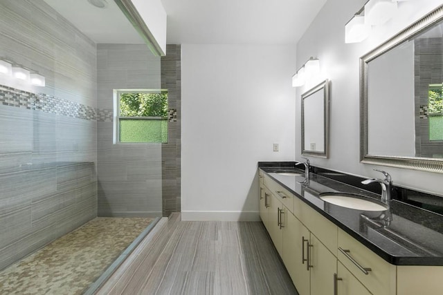 bathroom featuring hardwood / wood-style flooring, vanity, and a tile shower