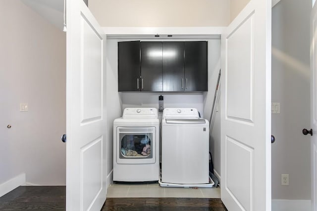 laundry room with cabinets, independent washer and dryer, and hardwood / wood-style flooring