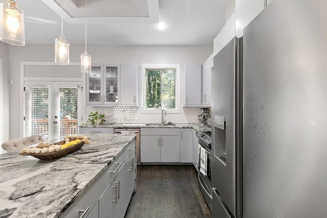 kitchen featuring tasteful backsplash, stainless steel appliances, sink, pendant lighting, and dark hardwood / wood-style floors