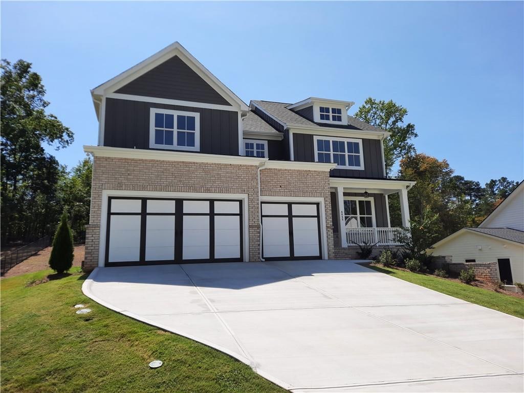 view of front of property featuring a front yard, a garage, and a porch