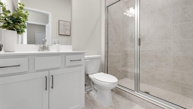 bathroom featuring tile patterned floors, a shower stall, toilet, and vanity