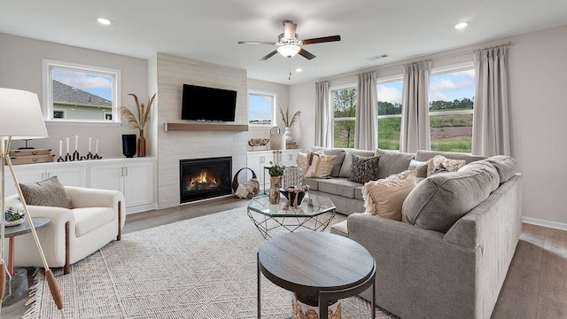 living room featuring recessed lighting, a tile fireplace, light wood-type flooring, a ceiling fan, and visible vents