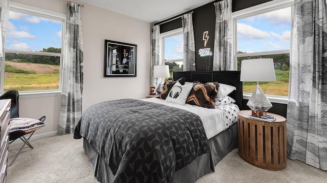 bedroom with baseboards and light carpet