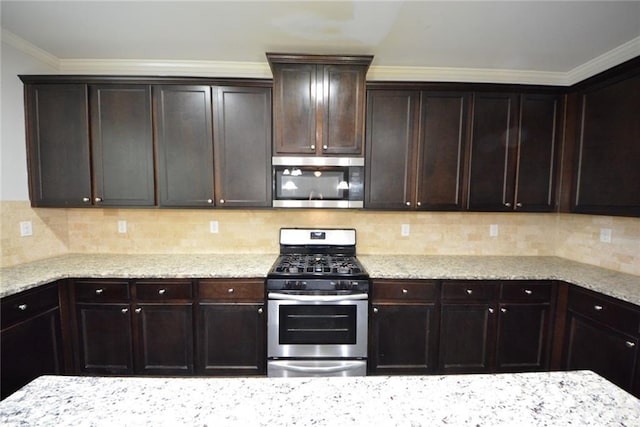 kitchen featuring stainless steel appliances, dark brown cabinetry, light stone countertops, and ornamental molding