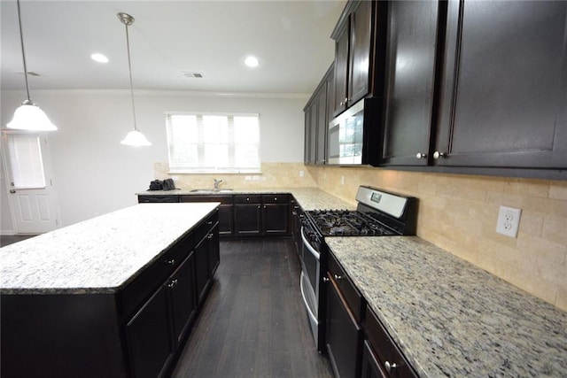 kitchen featuring stainless steel appliances, a sink, a center island, dark wood-style floors, and light stone countertops