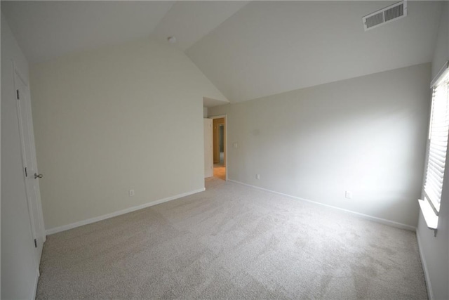 unfurnished room featuring light carpet, lofted ceiling, healthy amount of natural light, and baseboards