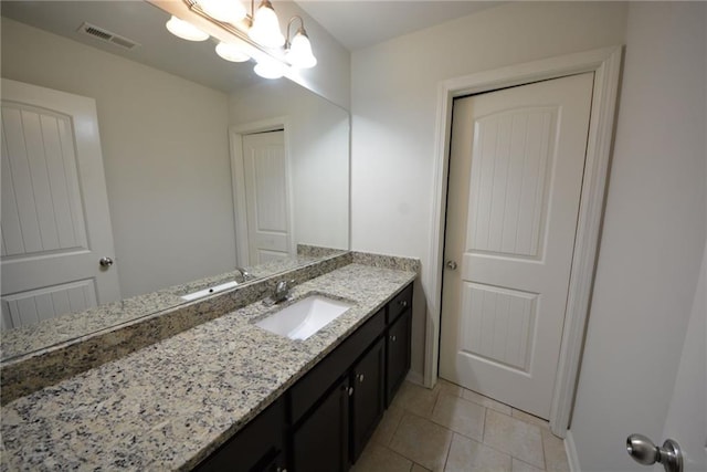 bathroom with tile patterned floors, vanity, baseboards, and a chandelier
