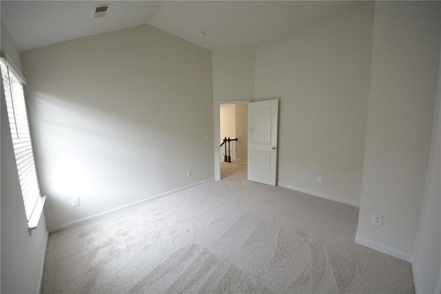 unfurnished bedroom featuring carpet, multiple windows, high vaulted ceiling, and baseboards