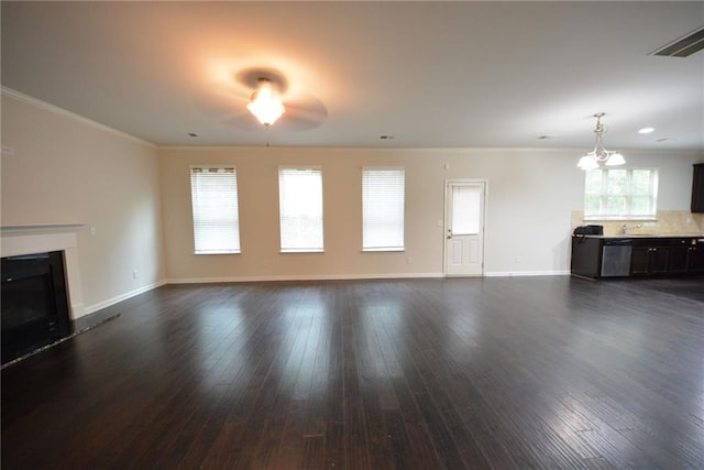 unfurnished living room with a fireplace with raised hearth, dark wood-type flooring, baseboards, and crown molding