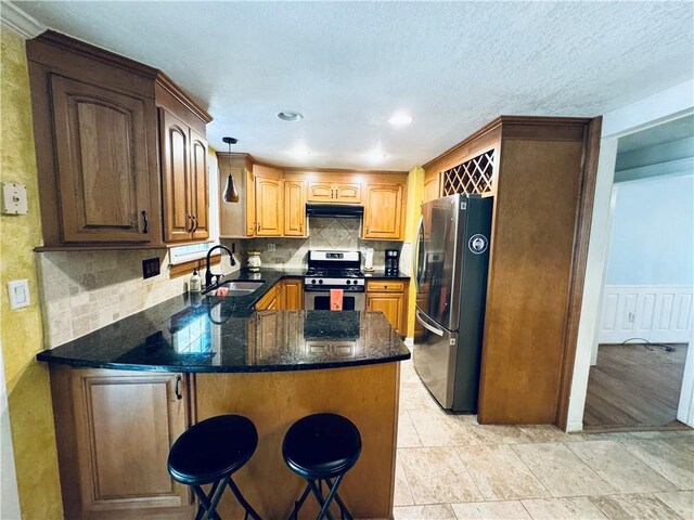 2606 Ramblewood Ct, Acworth, GA 30102 - kitchen featuring decorative light fixtures, sink, backsplash, kitchen peninsula, and stainless steel appliances