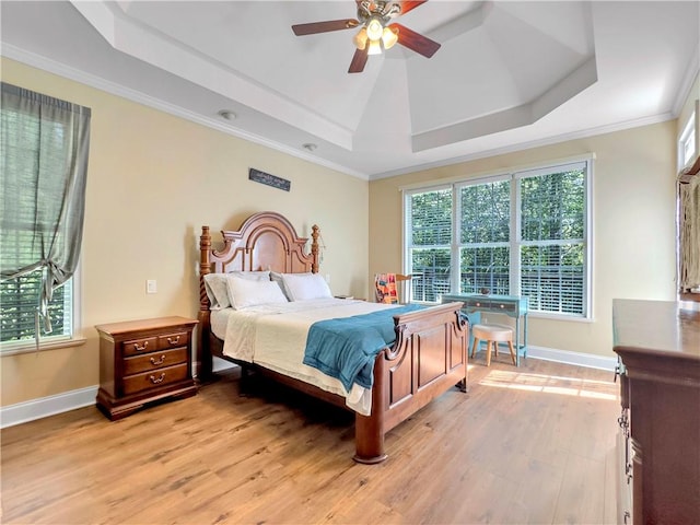 bedroom featuring a raised ceiling, ceiling fan, crown molding, and light wood-type flooring