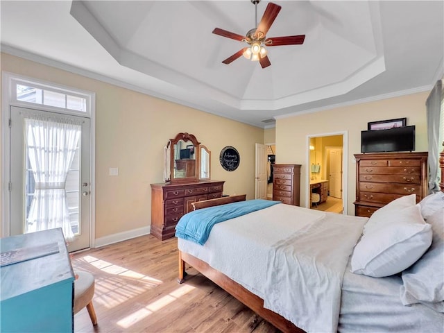 bedroom featuring connected bathroom, ceiling fan, a raised ceiling, light hardwood / wood-style flooring, and access to outside