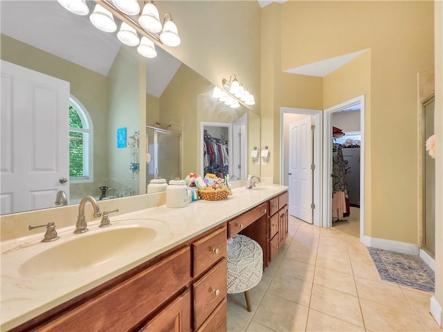 bathroom featuring tile patterned floors, vanity, an enclosed shower, and vaulted ceiling