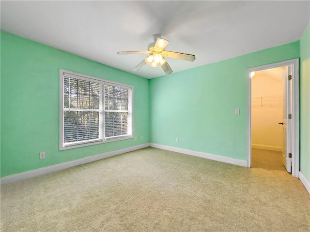 empty room with ceiling fan and light carpet