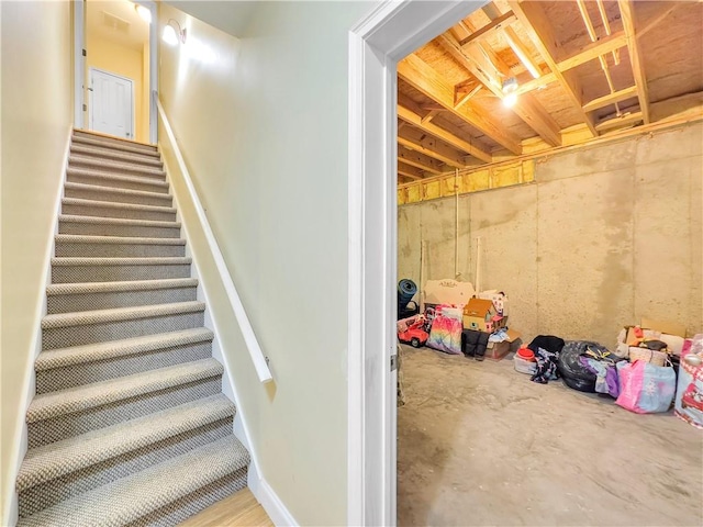 staircase featuring concrete flooring