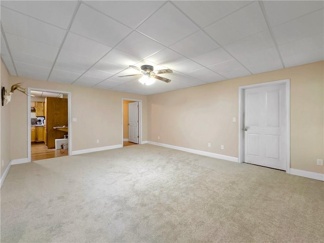 interior space with carpet flooring, a drop ceiling, and ceiling fan