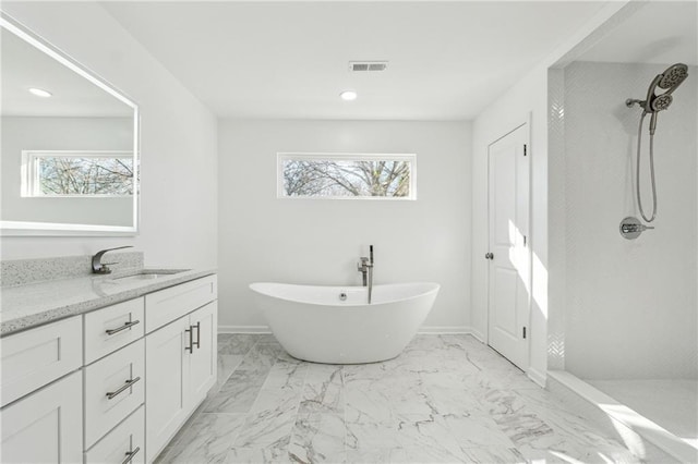 bathroom with independent shower and bath, vanity, and plenty of natural light