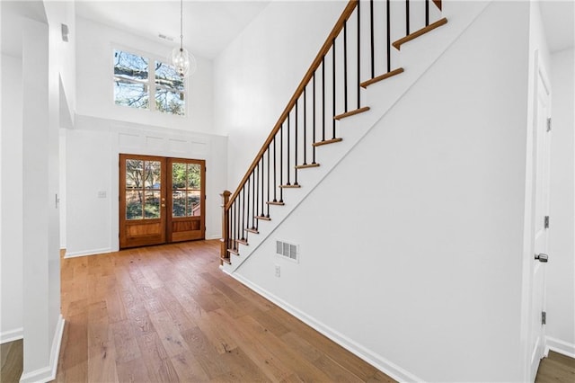 foyer entrance featuring hardwood / wood-style floors, a wealth of natural light, and french doors