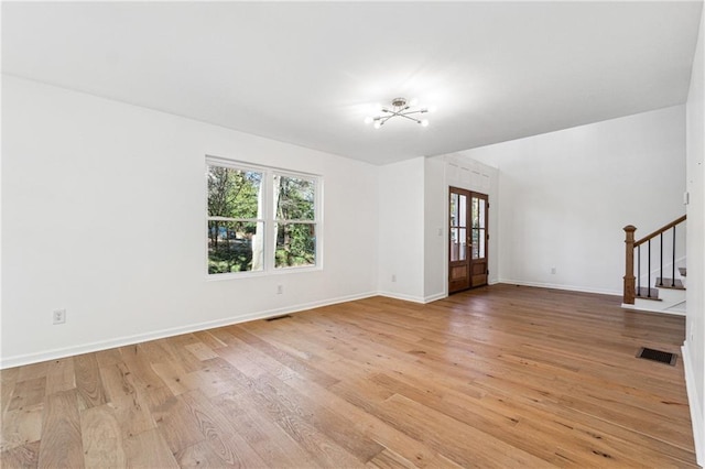 unfurnished living room featuring french doors and light wood-type flooring