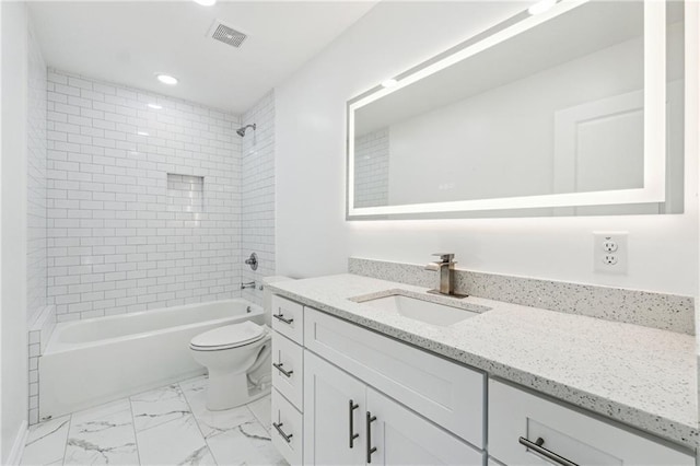 full bathroom with vanity, tiled shower / bath, and toilet