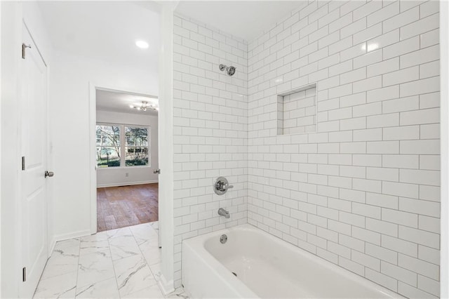 bathroom featuring tiled shower / bath