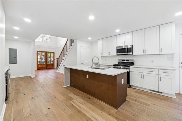 bar with white cabinetry, wine cooler, and light wood-type flooring