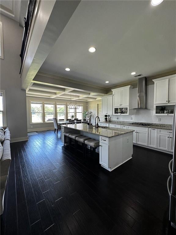 2657 Gray Mill Way, Loganville, GA 30052 - kitchen with wall chimney exhaust hood, recessed lighting, a center island with sink, light stone countertops, and white cabinets
