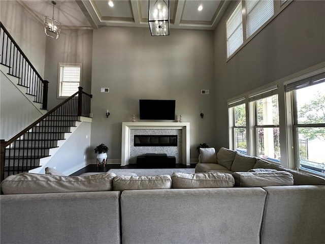 2657 Gray Mill Way, Loganville, GA 30052 - living room featuring a chandelier, a towering ceiling, stairs, coffered ceiling, and beam ceiling