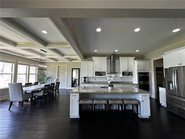 2657 Gray Mill Way, Loganville, GA 30052 - kitchen with stainless steel appliances, wall chimney exhaust hood, white cabinetry, crown molding, and a kitchen island