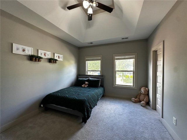 2657 Gray Mill Way, Loganville, GA 30052 - carpeted bedroom featuring a tray ceiling, a ceiling fan, and baseboards