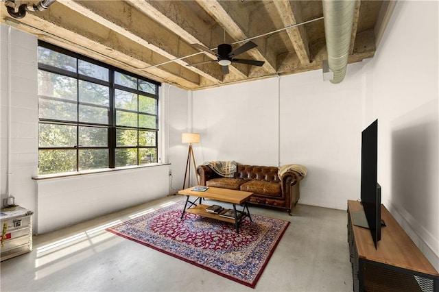 living area featuring concrete flooring and ceiling fan