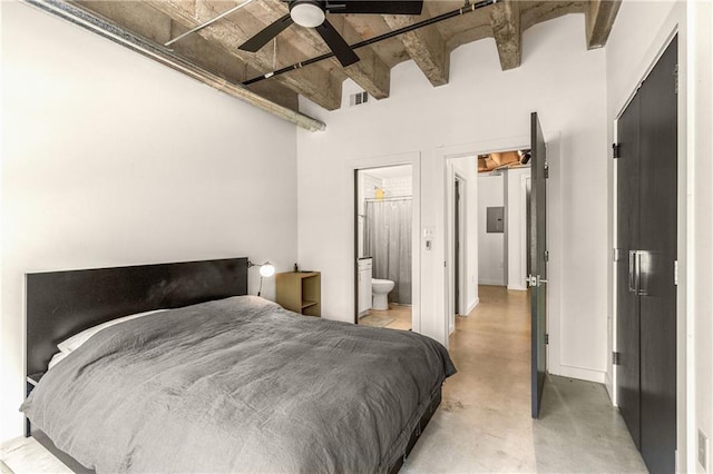 bedroom with finished concrete floors, beamed ceiling, visible vents, and connected bathroom