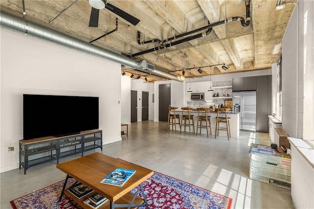 living room with finished concrete floors, visible vents, and a ceiling fan