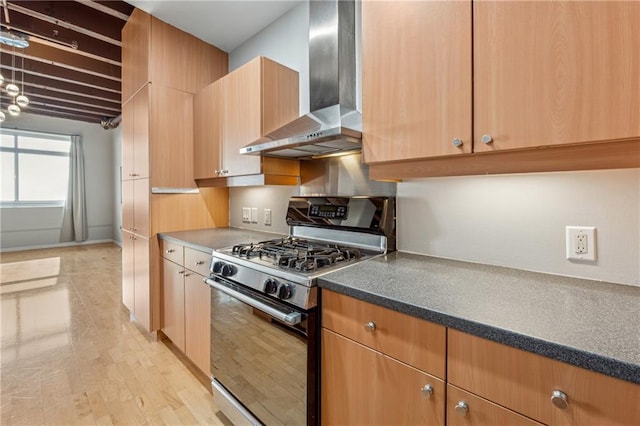 kitchen featuring wall chimney range hood and stainless steel gas stove