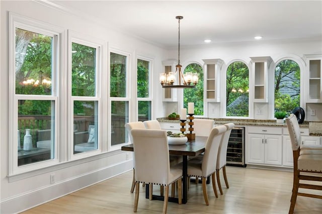 790 Thornberry Dr, Alpharetta, GA 30022 - dining area with beverage cooler, a chandelier, crown molding, plenty of natural light, and light wood-type flooring