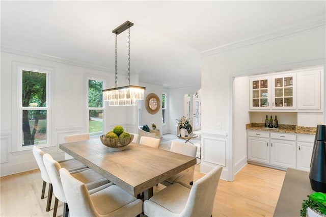 790 Thornberry Dr, Alpharetta, GA 30022 - dining area featuring light wood finished floors, a chandelier, crown molding, and a bar