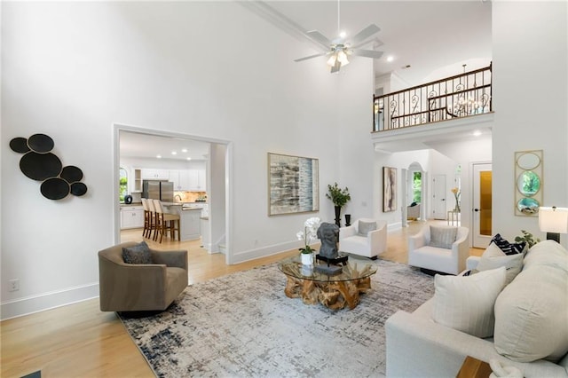 790 Thornberry Dr, Alpharetta, GA 30022 - living area featuring light wood-type flooring, ceiling fan, a high ceiling, baseboards, and arched walkways
