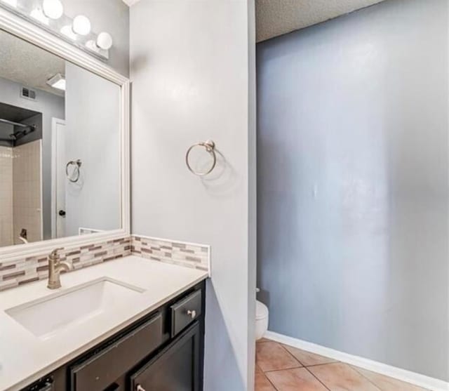 bathroom featuring toilet, tasteful backsplash, vanity, and tile patterned floors