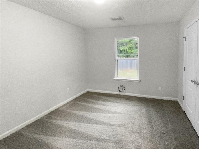 carpeted spare room with a textured ceiling