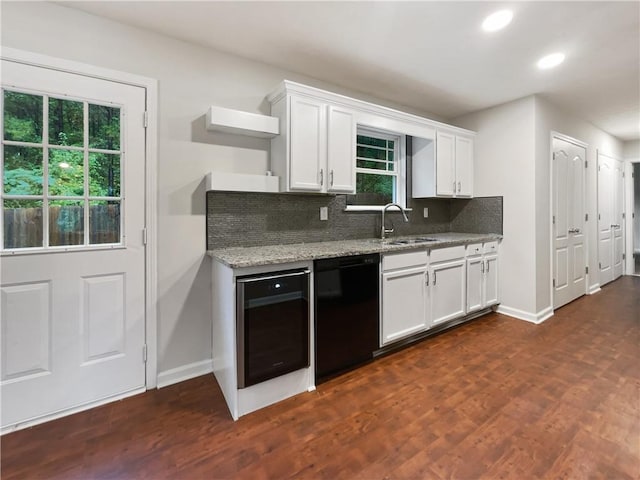 kitchen featuring decorative backsplash, black dishwasher, a wealth of natural light, and white cabinets