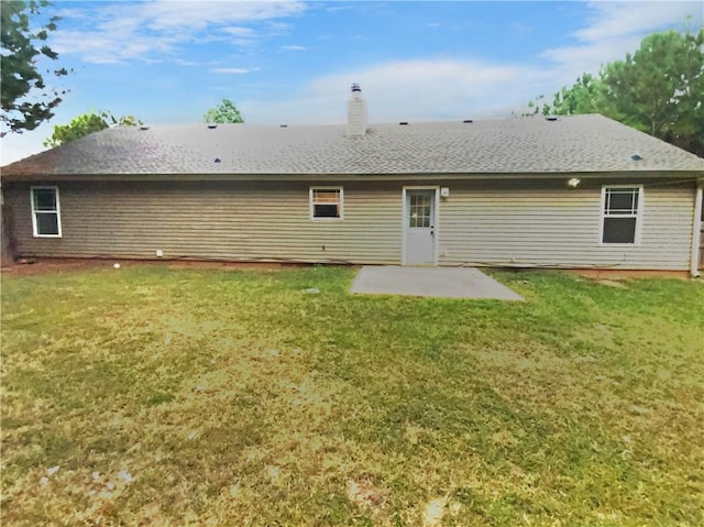 rear view of house with a lawn and a patio